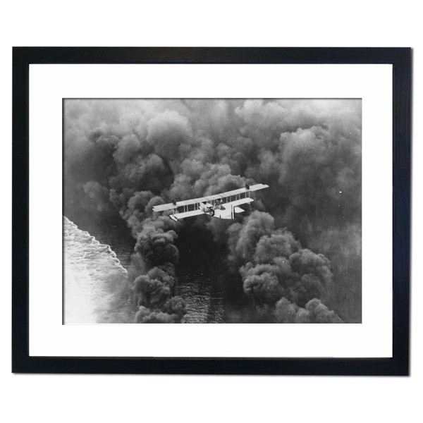 A striking aerial picture of a US Naval seaplane balanced over a dense smoke screen, California 1927 Framed Print